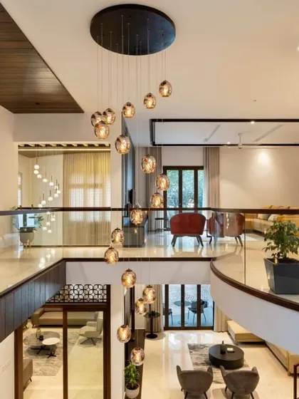 Looking down from the mezzanine level, you can appreciate the open, airy feeling of the home. The cascading pendant lights draw the eye downwards and connect the two floors visually.