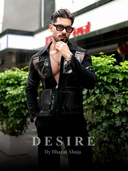 A full-body shot that showcases the unique design of the black utility shirt. It's a statement of confidence and modern luxury.