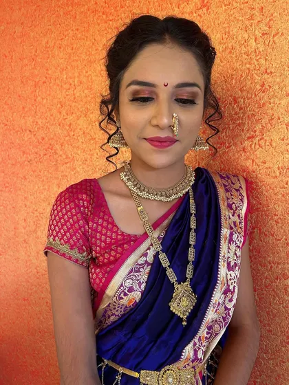 A classic portrait of a bride in a blue and pink nauvari. The makeup is kept natural and glowing to let the bride's beauty shine.