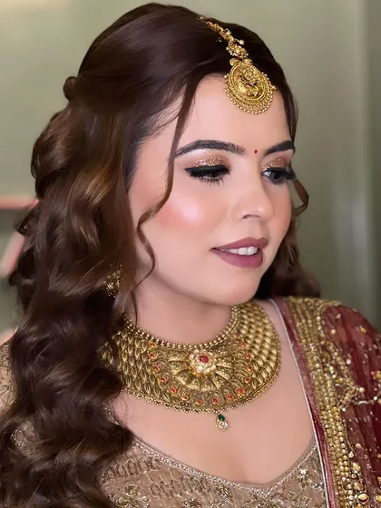 A close-up of the makeup, showing the soft brown smokey eye with a touch of gold glitter and a matte nude lipstick.