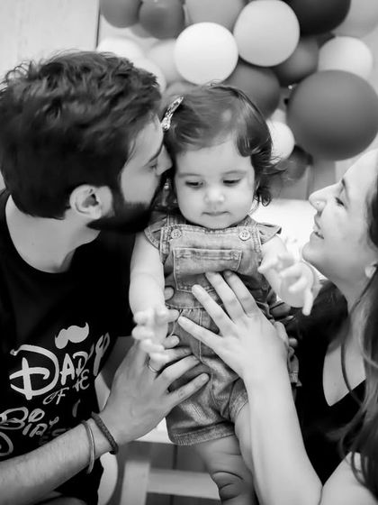 A timeless black and white family portrait from a first birthday photoshoot. This classic style emphasizes the emotional connection and love within the family.