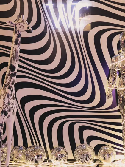 A full view of the window display we designed, combining a disco mannequin, a custom-painted giraffe, and a bold, wavy backdrop. This created a visually arresting scene that drew attention from the street.