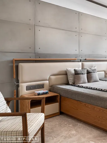 A closer look at the custom bed with its integrated side table and upholstered headboard. The tactile quality of the materials creates a sense of grounded, refined comfort.