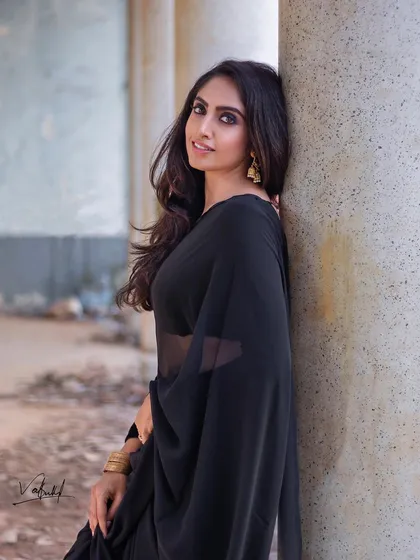 The timeless elegance of a black saree. For this shoot, we used the beautiful texture of old pillars as a backdrop to complement the simple grace of the attire, creating a classic and powerful portrait.