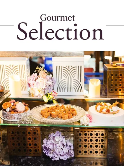Our gourmet selection is where creativity meets tradition. This dessert station showcases a variety of cakes and pastries on elegant, modern stands, creating a visually stunning display.