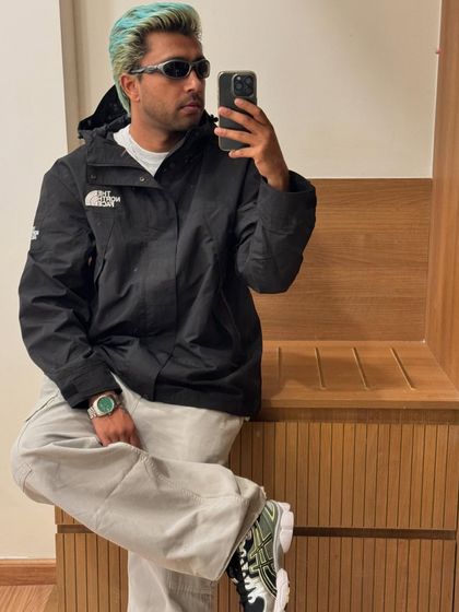 Another mirror selfie, showing off a classic black jacket and some fresh kicks.