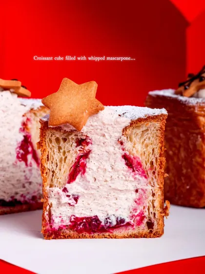 A cross-section reveals the creamy, fruity filling inside the flaky croissant layers.