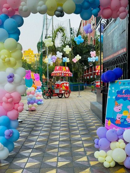 The entrance to a Peppa Pig party, showcasing the beautiful pastel balloon arch and themed welcome sign that creates an inviting atmosphere.