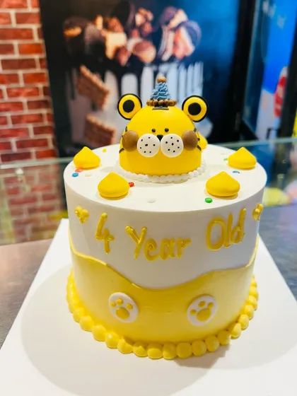 A cute yellow tiger-themed cake for a 4-year-old's birthday party.