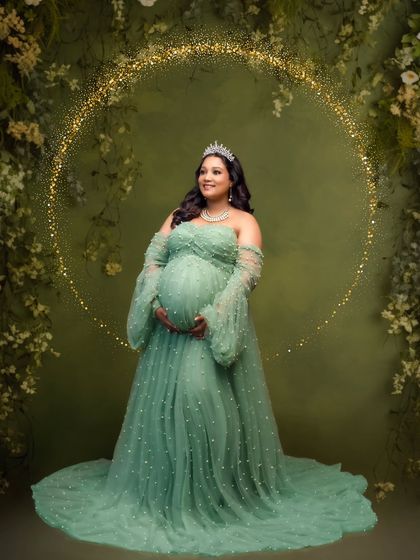 A magical portrait in a pearl-studded green tulle gown, enhanced with a sparkling golden halo effect for a touch of fantasy.