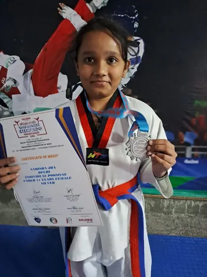 This is Sarisha Jha with her Silver medal and certificate from the 4th Aryan's Cup Open National Taekwondo Championship in 2022. Competing at the national level is a significant accomplishment.