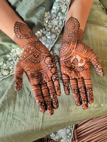 This full-hand design is perfect for any festival, including Karwa Chauth. It features a mix of traditional Indian motifs like paisleys, florals, and hanging bells, creating a dense and beautiful pattern.