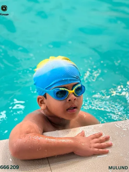 Splish splash, it's a swim time bash. A young competitor holds on to the side of the pool, waiting for his race to begin.