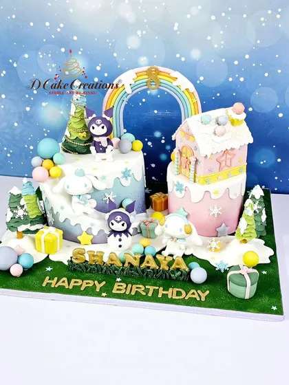 A whimsical winter wonderland cake for Shanaya's birthday. This unique design features two separate cakes connected by a rainbow, with cute characters and a gingerbread-style house.