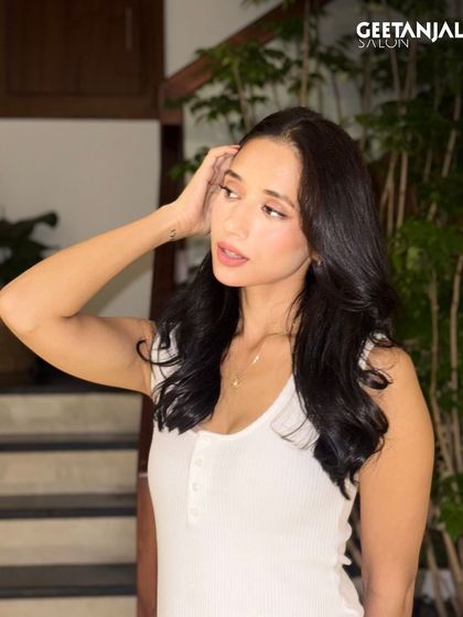 A candid shot of the client with her classic black hair, showing its natural movement and shine.