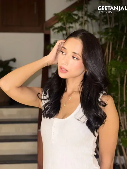 A candid shot of the client with her classic black hair, showing its natural movement and shine.