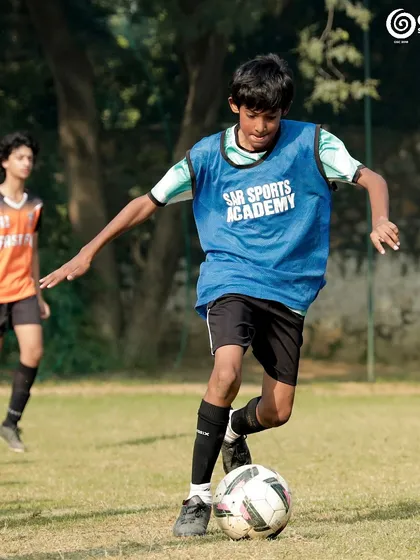 A player from our academy dribbles the ball with confidence, showcasing the ball control skills we develop in our youth programs.
