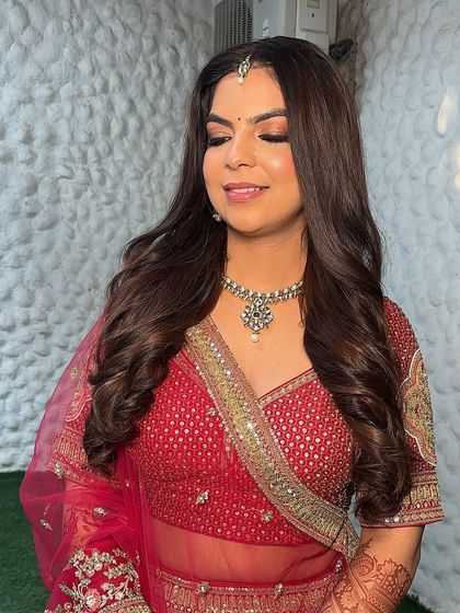 The final look, ready for the wedding. Her hair is styled in soft waves, and her makeup is glowing and radiant.