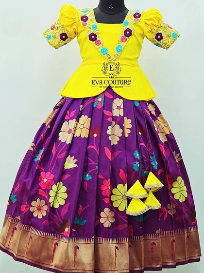 A floral lehenga in purple and yellow. The blouse has a modern V-neck with floral embroidery on the sleeves.