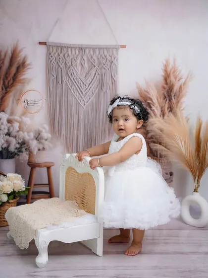 Using props like this miniature bench helps babies who are just learning to stand, providing support while creating a beautiful photo opportunity.