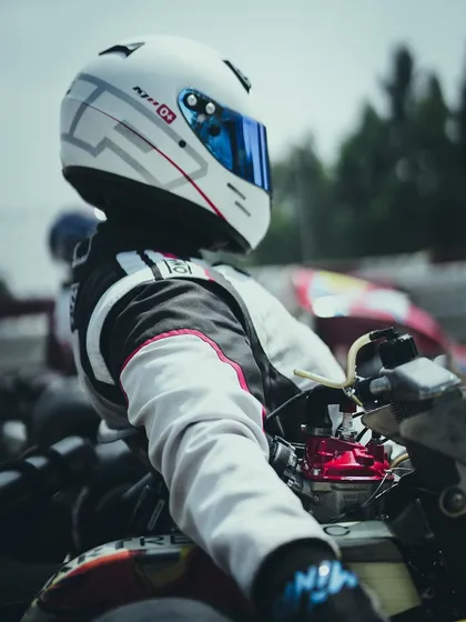 A close-up of a driver in his kart on the grid.