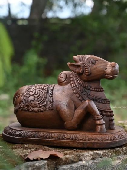 A side view of the 13.5-inch Nandi sculpture, showing the detailed carving on its back and the gentle curve of its body.