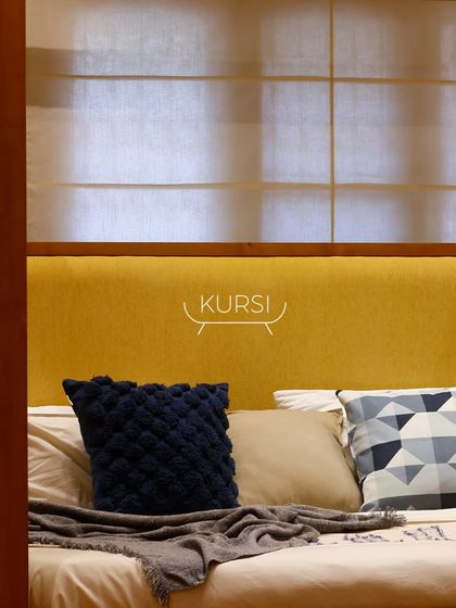 A bold statement in the bedroom. This custom four-poster bed is made from dark-stained teak wood with a vibrant yellow fabric headboard, redefining the space.