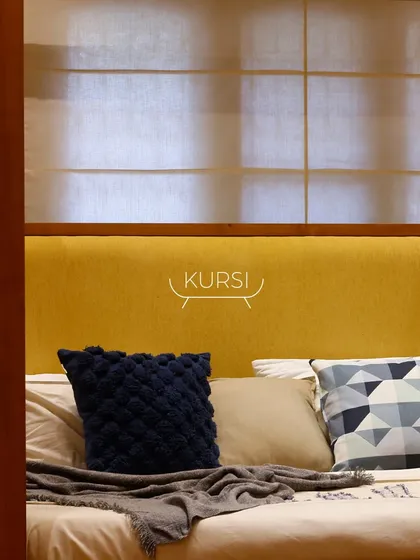 A bold statement in the bedroom. This custom four-poster bed is made from dark-stained teak wood with a vibrant yellow fabric headboard, redefining the space.