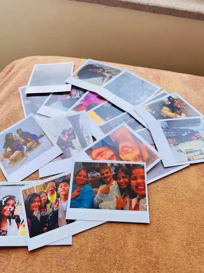Another view of a large batch of custom Polaroid prints, showing a variety of moments from selfies with friends to family gatherings.
