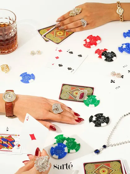A festive flatlay capturing the excitement of a Diwali card party. The scene is styled with playing cards, poker chips, and dazzling jewellery, blending tradition with modern glamour.