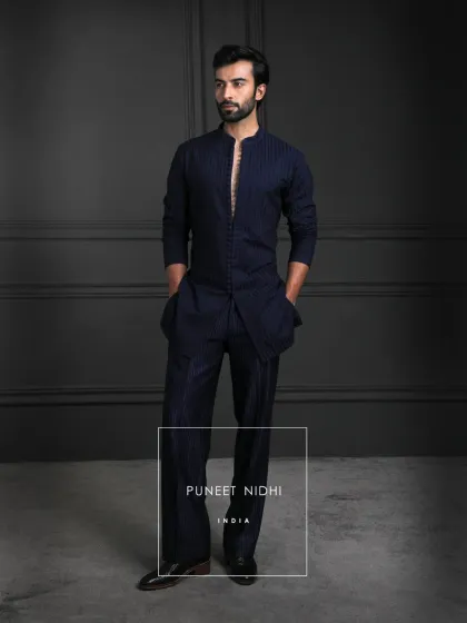 Elegance in every thread. A deep navy bandhgala-style jacket with intricate geometric embroidery, paired seamlessly with a loop-buttoned tunic and bell-bottom textured lowers.