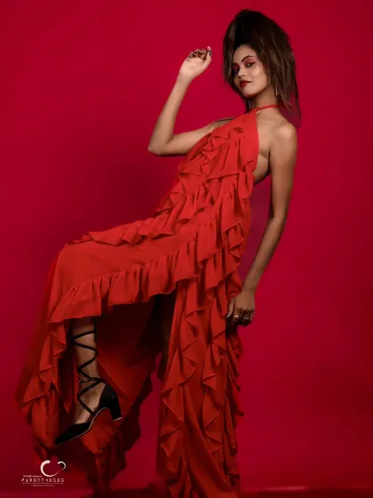 A dynamic and expressive pose in a ruffled red gown. The movement and energy in this shot are palpable, creating a sense of high-fashion drama.