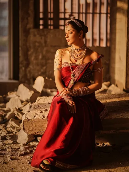 A moment of quiet contemplation. This image of Nyra Banerjee, seated amidst rubble, creates a beautiful contrast between the raw setting and the refined, royal styling.