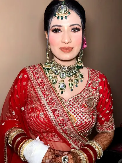 A close-up view of the bride's emerald and kundan choker, maang tikka, and earrings.