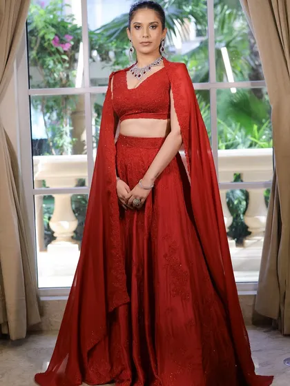 This full-length shot shows how the makeup complements the entire outfit. The red cape dress is a statement, and the soft glam makeup ensures the overall look is balanced and chic.