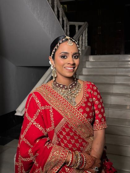 Regal, radiant, and breathtakingly beautiful. This bride embodied timeless elegance in her stunning red Sabyasachi lehenga, complemented by rich gold tones and deep browns in her makeup.