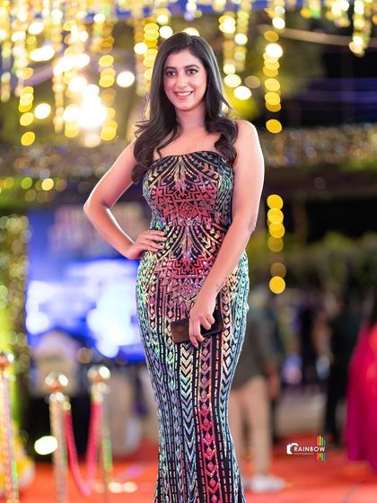 A guest posing against the beautifully lit background of the event.