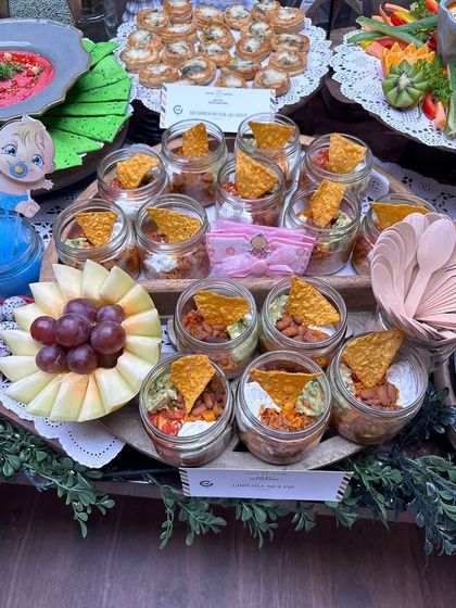 For this baby shower, we created adorable individual seven-layer dip jars. This presentation is not only charming but also practical for guests to enjoy while mingling.
