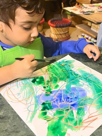 This young student is deeply focused on his crayon-resist watercolor painting. It's a magical process for them to see the crayon marks reappear.