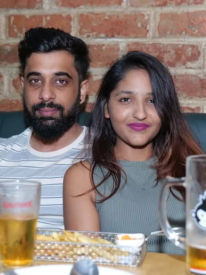 A couple enjoying beers and snacks.