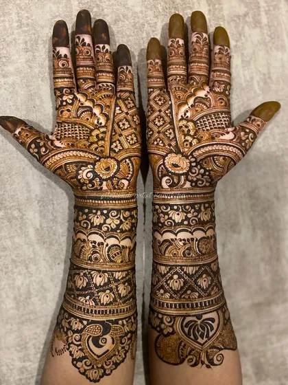 A beautiful bridal design with a focus on floral and paisley patterns. The heart-shaped motif on the arm adds a touch of romance to this traditional piece.