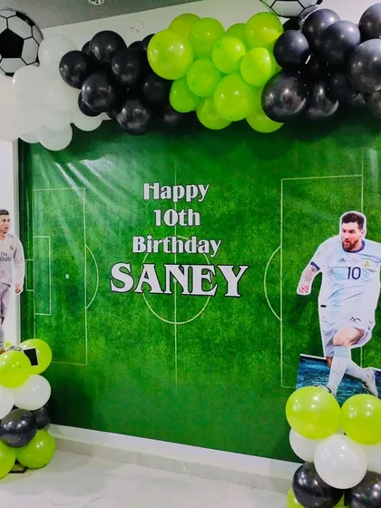 For the sports fans, we offer themed decorations like this football party setup. It includes a custom football pitch backdrop, player cutouts, and balloons in team colors for a 10th birthday.