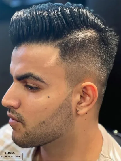 A sharp, high-contrast fade with a defined side part. This style is perfect for making a bold statement and showcases our precision cutting.