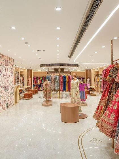 A view from the staircase landing on the ready-to-wear floor. The open layout and bright lighting create a spacious and inviting atmosphere for shoppers.