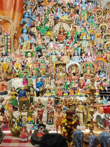 A close-up look at one of the most densely populated displays at the Navaratra festival. This arrangement, featuring hundreds of dolls, represents the celestial court and various deities, showcasing the richness of Hindu iconography.