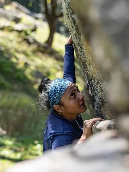 A climber looks up, planning her next move. The mental game of climbing is just as important as the physical one.