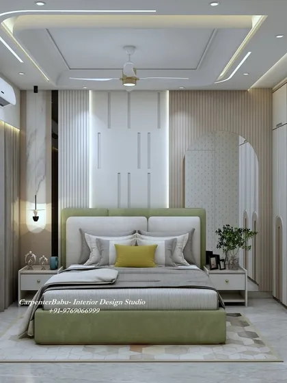 This bedroom at Neelkanth, Thane, uses a soft green for the bed, creating a calm and refreshing atmosphere. The headboard wall features a mix of textures and a large, arched mirror.