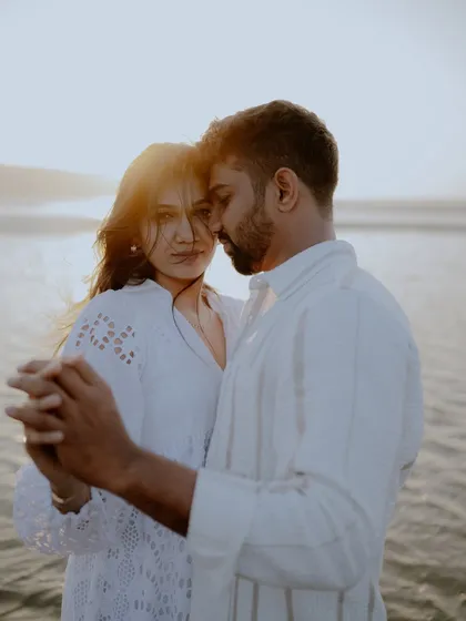 A tender moment of the couple dancing on the beach at sunset. The warm light and their close hold create a dreamy and cinematic feel.