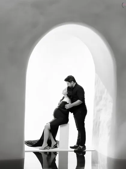 Sometimes, the most powerful stories are told in black and white. This intimate couple portrait, framed by a simple archway, focuses purely on the connection and anticipation between two people about to become parents.