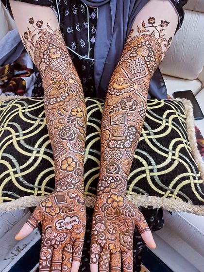 A beautiful bridal design with the name 'Issam' on the palm, surrounded by a dense floral pattern.